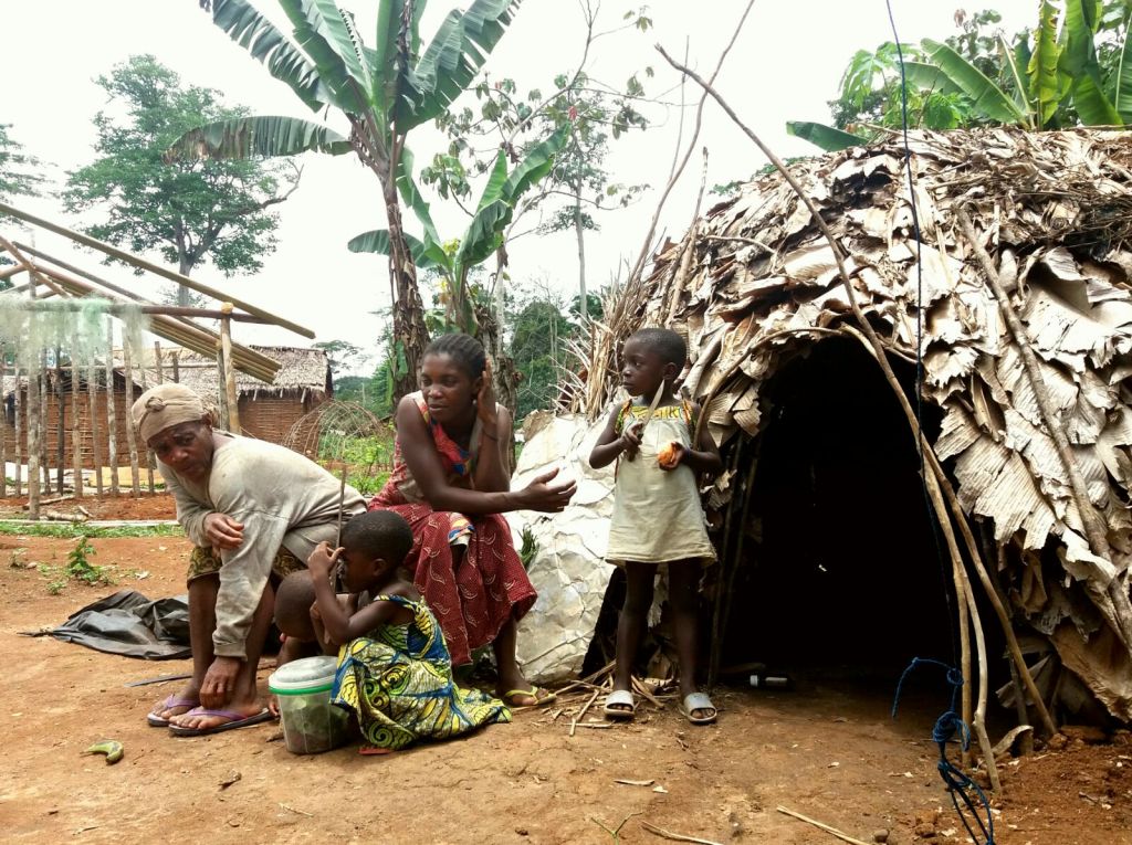 Cameroon 24-029 Baka women and children outside traditional hut, Credit - Eva Avila